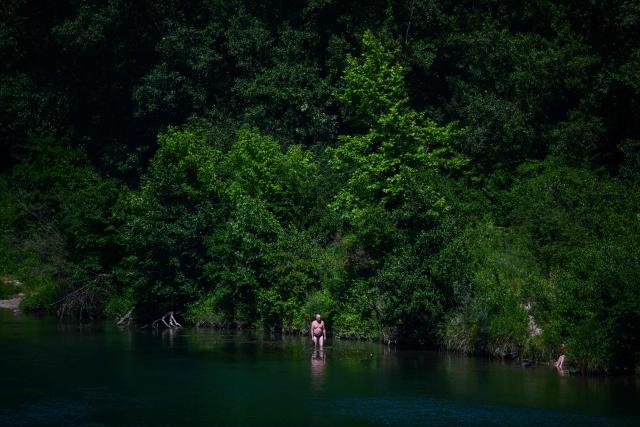 A man bathes in the Rhone river in the centre of Lyon, south-eastern France on June 18, 2026. (Photo by OLIVIER CHASSIGNOLE / AFP)