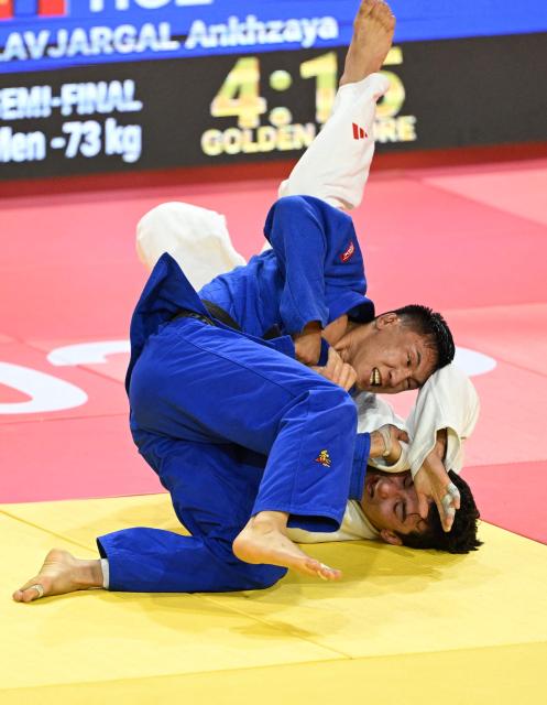 Ankhzaya Lavjargal of Mongolia (blue) competes with Irakli Goginashvili of Britain (white) in their semi-final for men under 73kg at the Judo Ulaanbaatar Grand Slam 2026 in Ulaanbaatar on June 20, 2026. (Photo by ADEK BERRY / AFP)