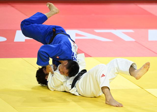 Ankhzaya Lavjargal of Mongolia (blue) competes with Irakli Goginashvili of Britain (white) in their semi-inal for men under 73kg at the Judo Ulaanbaatar Grand Slam 2026 in Ulaanbaatar on June 20, 2026. (Photo by ADEK BERRY / AFP)