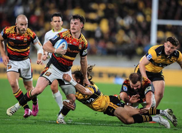 Chiefs Leroy Carter breaks the tackle of Hurricanes Ereatara Enari during the Super Rugby Pacific final match between the Wellington Hurricanes and Waikato Chiefs in Wellington on June 20, 2026. (Photo by Grant Down / AFP)