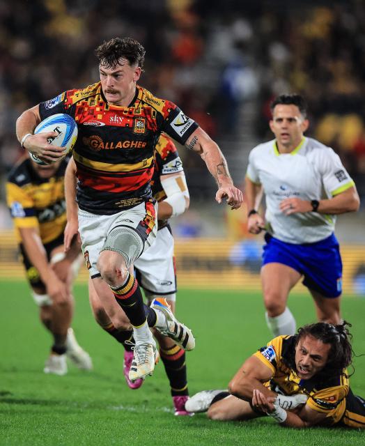 Chiefs Leroy Carter breaks the tackle of Hurricanes Ereatara Enari during the Super Rugby Pacific final match between the Wellington Hurricanes and Waikato Chiefs in Wellington on June 20, 2026. (Photo by Grant Down / AFP)