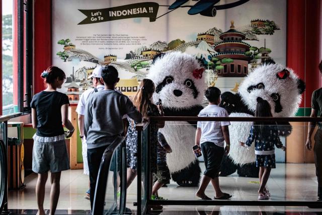 Panda mascots welcome visitors to the Panda Palace of Taman Safari Indonesia in Bogor, West Java, on June 20, 2026. (Photo by Yasuyoshi Chiba / AFP)