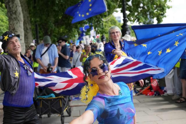 Protesters wave Union and EU (European Union) flags during a National 'rejoin the EU' march in central London on June 20, 2026. (Photo by CARLOS JASSO / AFP)
