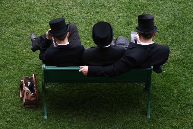 Racegoers relax ahead of racing on the fifth day of the Royal Ascot horse racing meeting in Ascot, west of London, on June 20, 2026. (Photo by Henry NICHOLLS / AFP)