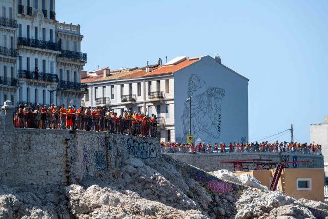 Volunteers and citizens form a human chain at the foot of the SOS MedMéditerranée mural on The Corniche Kennedy in Marseille, south-eastern France on June 20, 2026, as they express their solidarity with the organisation on its tenth anniversary. (Photo by MIGUEL MEDINA / AFP)