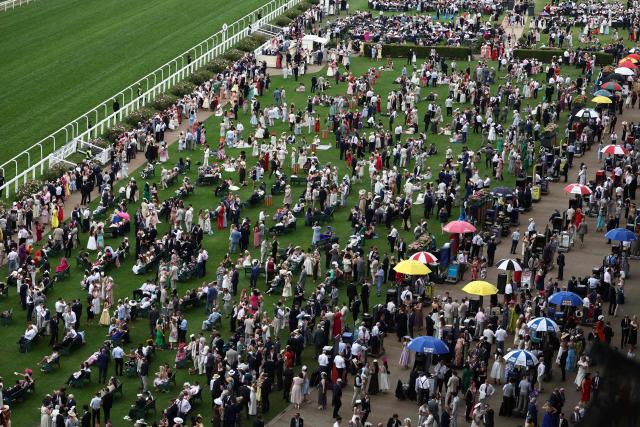 Racegoers await the Royal Procession in front of the grandstands ahead of racing on the fifth day of the Royal Ascot horse racing meeting in Ascot, west of London, on June 20, 2026. (Photo by Henry Nicholls / AFP)