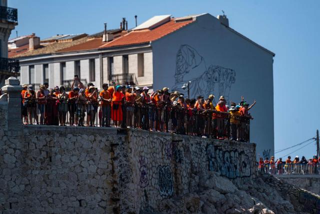 Volunteers and citizens form a human chain at the foot of the SOS MedMéditerranée mural on The Corniche Kennedy in Marseille, south-eastern France on June 20, 2026, as they express their solidarity with the organisation on its tenth anniversary. (Photo by MIGUEL MEDINA / AFP)
