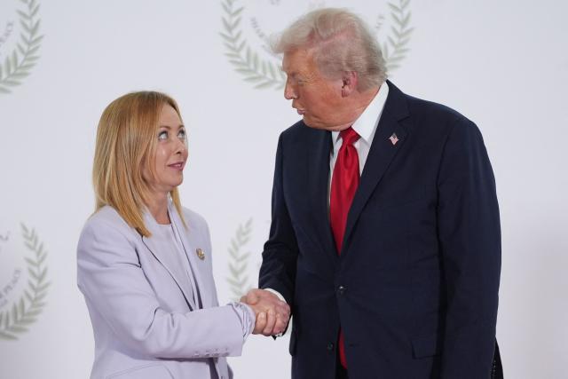 (FILES) US President Donald Trump greets Italy's Prime Minister Giorgia Meloni during a summit on Gaza in Sharm el-Sheikh on October 13, 2025. Trump insists on June 20, 2026 Italian PM Meloni 'asked, over and over' for photo with him at G7. (Photo by Evan Vucci / POOL / AFP)