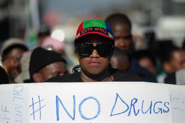 A group of about 100 people, some carrying banners, take part in a march, organised by the March and March movement, protesting against illegal immigrants, in Wynberg, a Cape Town suburb, on June 20, 2026. (Photo by RODGER BOSCH / AFP)