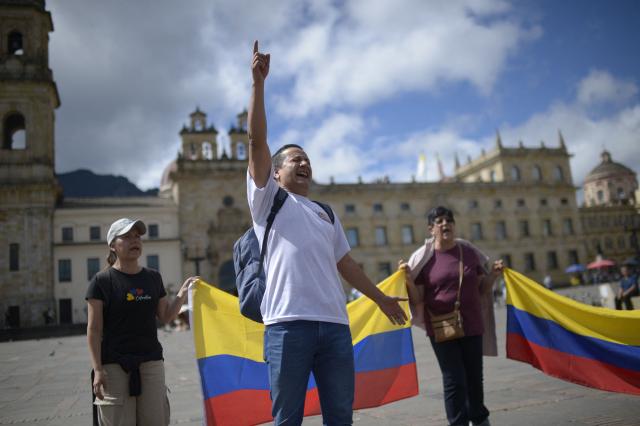 Christians hold Colombian national flags as they pray for the future of the country at Murillo square in Bogota, on June 20, 2026, the day before the presidential runoff election. Colombians vote on June 21, 2026 in a presidential runoff pitting a hard-right opera-singer-turned-lawyer against a leftist senator, an election with stark consequences for the country's stumbling peace process with armed groups and strained ties with Washington. (Photo by Sebastian BARROS / AFP)