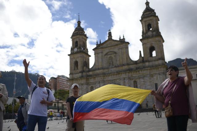 Christians hold a Colombian national flag as they pray for the future of the country at Murillo square in Bogota, on June 20, 2026, the day before the presidential runoff election. Colombians vote on June 21, 2026 in a presidential runoff pitting a hard-right opera-singer-turned-lawyer against a leftist senator, an election with stark consequences for the country's stumbling peace process with armed groups and strained ties with Washington. (Photo by Sebastian BARROS / AFP)