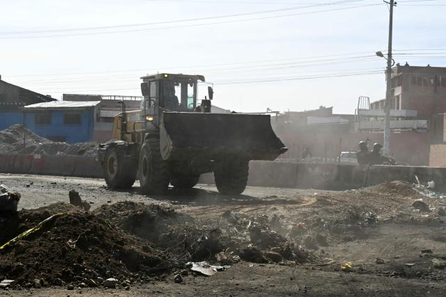 A backhoe breaks down a barricade at a blockade zone in Cruce Ventilla in El Alto, Bolivia on June 20, 2026, after Bolivian president Rodrigo Paz declared state of emergency. Bolivian President Rodrigo Paz declared a state of emergency across the Latin American country after more than six weeks of road blockades and protests demanding his resignation, saying he had exhausted "all avenues of dialogue." (Photo by AIZAR RALDES / AFP)