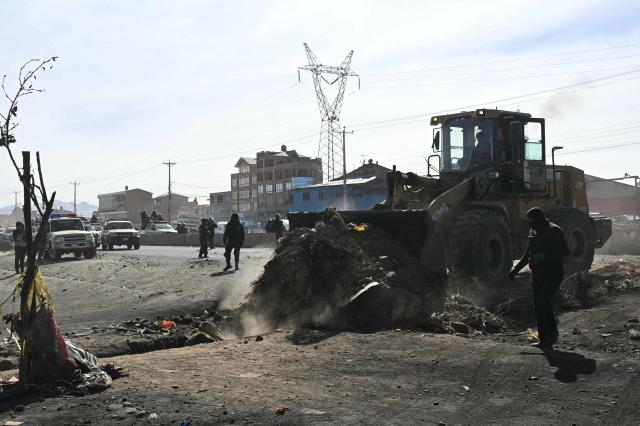 A backhoe breaks down a barricade at a blockade zone in Cruce Ventilla in El Alto, Bolivia on June 20, 2026, after Bolivian president Rodrigo Paz declared state of emergency. Bolivian President Rodrigo Paz declared a state of emergency across the Latin American country after more than six weeks of road blockades and protests demanding his resignation, saying he had exhausted "all avenues of dialogue." (Photo by AIZAR RALDES / AFP)