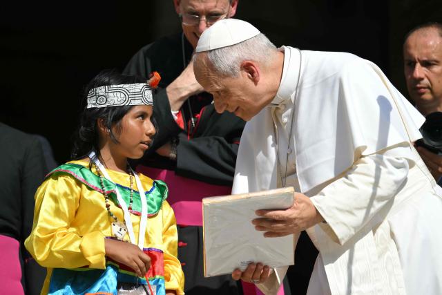 Pope Leo XIV speaks with a child at Piazza Duomo during a pastoral visit in Pavia on June 20, 2026. (Photo by Marco BERTORELLO / AFP)