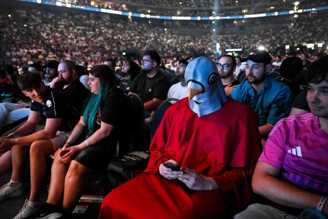 A supporter in a fancy dress checks his mobile phone during the semi-final of the IEM Cologne Major 2026 Counter Strike tournament at the Lanxess Arena in Cologne, western Germany ob June 20, 2026. (Photo by Ina FASSBENDER / AFP)