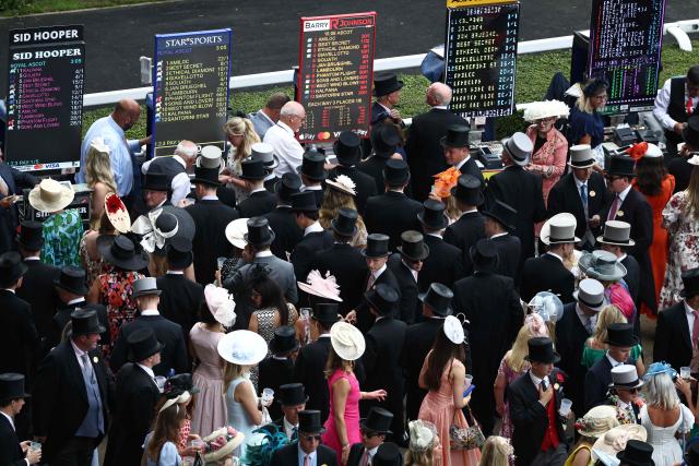 Racegoers wait to place bets on the Queen Elizabeth II Jubilee Stakes horse race on the fifth day of the Royal Ascot horse racing meeting in Ascot, west of London, on June 20, 2026. (Photo by Henry NICHOLLS / AFP)