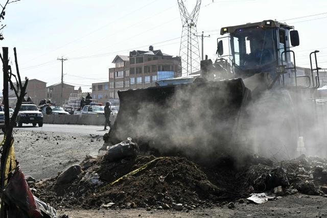 A backhoe breaks down a barricade at a blockade zone in Cruce Ventilla in El Alto, Bolivia on June 20, 2026, after Bolivian president Rodrigo Paz declared state of emergency. Bolivian President Rodrigo Paz declared a state of emergency across the Latin American country after more than six weeks of road blockades and protests demanding his resignation, saying he had exhausted "all avenues of dialogue." (Photo by AIZAR RALDES / AFP)