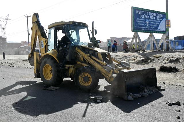 A backhoe breaks down a barricade at a blockade zone in Cruce Ventilla in El Alto, Bolivia on June 20, 2026, after Bolivian president Rodrigo Paz declared state of emergency. Bolivian President Rodrigo Paz declared a state of emergency across the Latin American country after more than six weeks of road blockades and protests demanding his resignation, saying he had exhausted "all avenues of dialogue." (Photo by AIZAR RALDES / AFP)