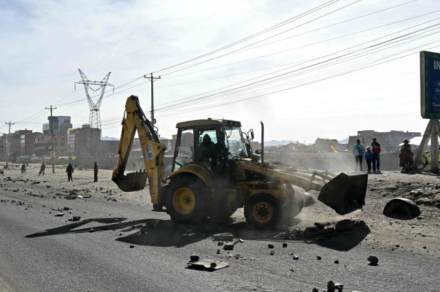 A backhoe breaks down a barricade at a blockade zone in Cruce Ventilla in El Alto, Bolivia on June 20, 2026, after Bolivian president Rodrigo Paz declared state of emergency. Bolivian President Rodrigo Paz declared a state of emergency across the Latin American country after more than six weeks of road blockades and protests demanding his resignation, saying he had exhausted "all avenues of dialogue." (Photo by AIZAR RALDES / AFP)