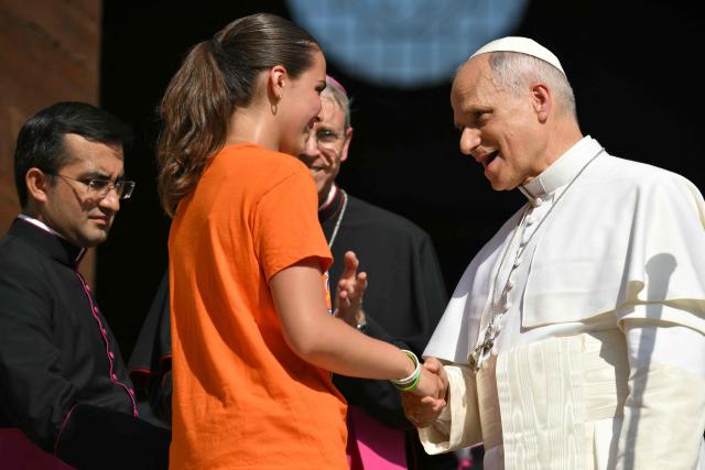 A young girl shakes hand to Pope Leo XIV outside the cathedral during a pastoral visit in Pavia on June 20, 2026. (Photo by Marco BERTORELLO / AFP)