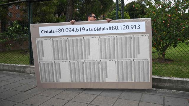 A man sets up an electoral roll outside a polling center in Bogota, on June 20, 2026, ahead of the presidential runoff election. Colombians vote on June 21, 2026 in a presidential runoff pitting a hard-right opera-singer-turned-lawyer against a leftist senator, an election with stark consequences for the country's stumbling peace process with armed groups and strained ties with Washington. (Photo by Luis ACOSTA / AFP)
