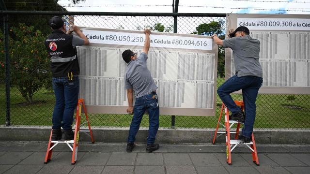 Men set up an electoral roll outside a polling center in Bogota, on June 20, 2026, ahead of the presidential runoff election. Colombians vote on June 21, 2026 in a presidential runoff pitting a hard-right opera-singer-turned-lawyer against a leftist senator, an election with stark consequences for the country's stumbling peace process with armed groups and strained ties with Washington. (Photo by Luis ACOSTA / AFP)