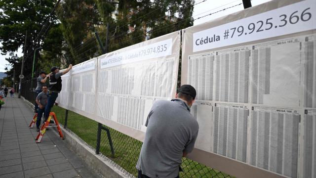 Men set up an electoral roll outside a polling center in Bogota, on June 20, 2026, ahead of the presidential runoff election. Colombians vote on June 21, 2026 in a presidential runoff pitting a hard-right opera-singer-turned-lawyer against a leftist senator, an election with stark consequences for the country's stumbling peace process with armed groups and strained ties with Washington. (Photo by Luis ACOSTA / AFP)