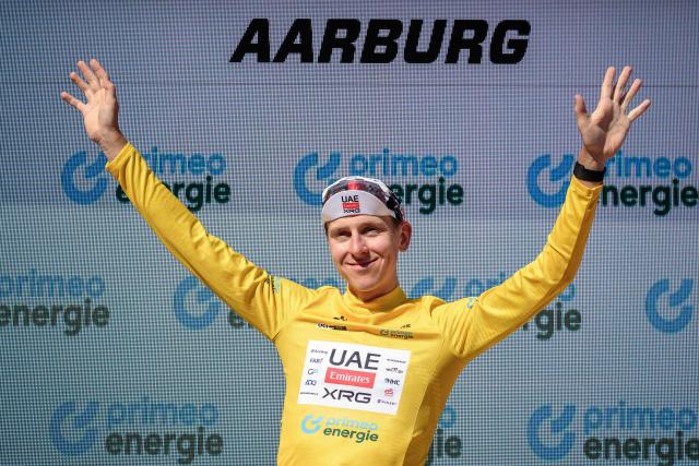 UAE Team Emirates-XRG's Slovenian rider Tadej Pogacar wearing the overall leader's yellow jersey celebrates on the podium of the fourth stage, a 23.7 km time trial from Aarburg to Aarburg, at the Men's Tour of Switzerland (Tour de Suisse) cycling race in Aarburg, Switzerland, on June 20, 2026. (Photo by Fabrice COFFRINI / AFP)
