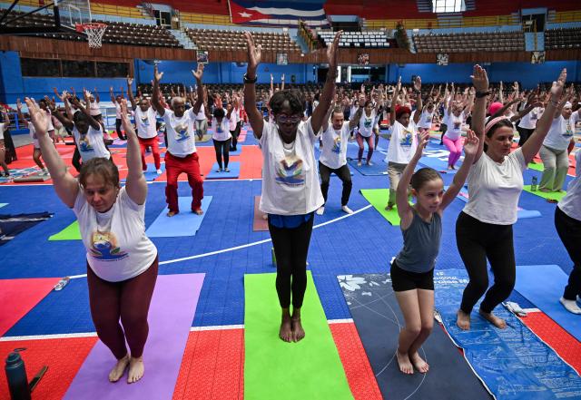 Yoga enthusiasts take part in a yoga session at the sports city to celebrate the International Yoga Day in Havana on June 20, 2026. (Photo by YAMIL LAGE / AFP)