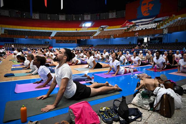 Yoga enthusiasts take part in a yoga session at the sports city to celebrate the International Yoga Day in Havana on June 20, 2026. (Photo by YAMIL LAGE / AFP)