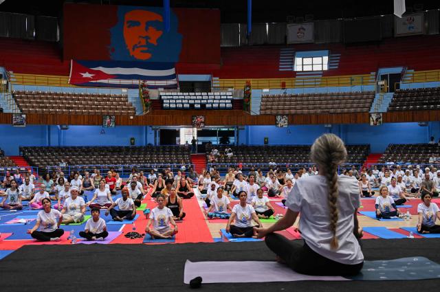 Yoga enthusiasts take part in a yoga session at the sports city to celebrate the International Yoga Day in Havana on June 20, 2026. (Photo by YAMIL LAGE / AFP)