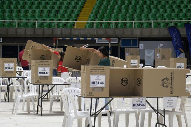 People arrange polling stations at a polling center in Cali, Colombia on June 20, 2026, the day before the presidential runoff election. Colombians vote on June 21, 2026 in a presidential runoff pitting a hard-right opera-singer-turned-lawyer against a leftist senator, an election with stark consequences for the country's stumbling peace process with armed groups and strained ties with Washington. (Photo by JOAQUIN SARMIENTO / AFP)