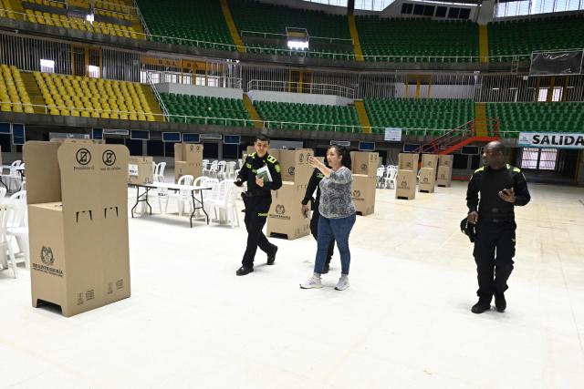Police walk at a polling center in Cali, Colombia on June 20, 2026, the day before the presidential runoff election. Colombians vote on June 21, 2026 in a presidential runoff pitting a hard-right opera-singer-turned-lawyer against a leftist senator, an election with stark consequences for the country's stumbling peace process with armed groups and strained ties with Washington. (Photo by Joaquin SARMIENTO / AFP)