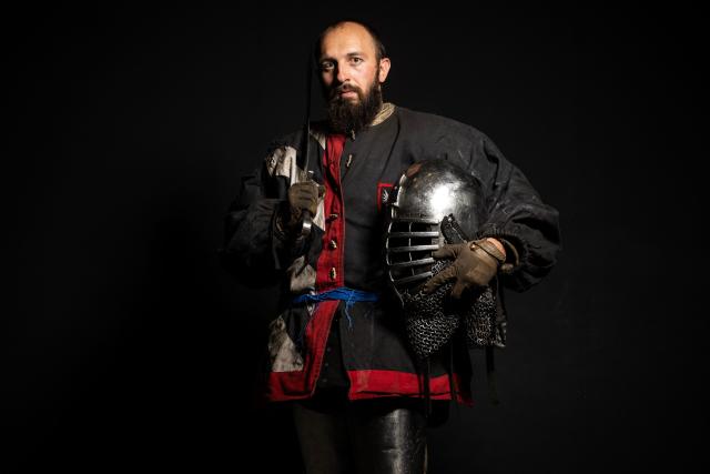 A competitor poses in his combat gear as part of the Knights of the Cage, a gala of the medieval armored combat or buhurt, in Onet-le-Chateau, southwestern France, on June 20, 2026. Fighters in armor with shields and swords, or axes, have taken part in about twenty fights in an MMA cage in Aveyron. It was overwhelmingly men who fought in individual "behourd profight" clashes, presented as the modern version of "what was the equivalent of MMA of the Middle Ages" by the town hall of Onet-le-Chateau. French, Polish, and British fighters participated in this event at the Salle d'Armes Ecole Ancienne (SAEA), a club specializing in buhurt.
"The word 'buhurt' comes from Old French; it was a recreational activity for men in the Middle Ages... It's the intersection of history and combat sports," explains Clement Carsac, president of SAEA Aveyron. 
Before the fights, participants must be weighed because, as in boxing, there are weight categories in buhurt profight. They then put on their armor and helmets, which can weigh up to six kilos. The outfit is rather expensive: "A complete set costs between 3,000 and 4,000 euros," according to Clement Carsac. (Photo by Valentine CHAPUIS / AFP)