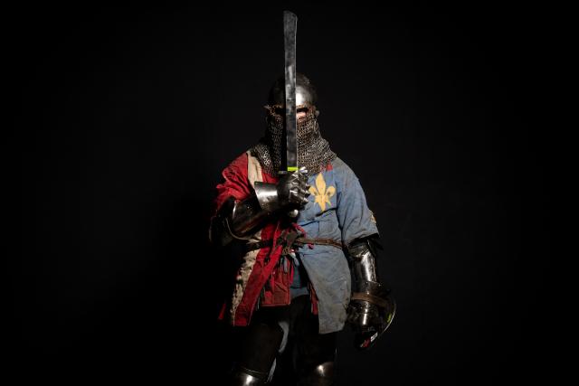 A competitor poses in his combat gear as part of the Knights of the Cage, a gala of the medieval armored combat or buhurt, in Onet-le-Chateau, southwestern France, on June 20, 2026. Fighters in armor with shields and swords, or axes, have taken part in about twenty fights in an MMA cage in Aveyron. It was overwhelmingly men who fought in individual "behourd profight" clashes, presented as the modern version of "what was the equivalent of MMA of the Middle Ages" by the town hall of Onet-le-Chateau. French, Polish, and British fighters participated in this event at the Salle d'Armes Ecole Ancienne (SAEA), a club specializing in buhurt.
"The word 'buhurt' comes from Old French; it was a recreational activity for men in the Middle Ages... It's the intersection of history and combat sports," explains Clement Carsac, president of SAEA Aveyron. 
Before the fights, participants must be weighed because, as in boxing, there are weight categories in buhurt profight. They then put on their armor and helmets, which can weigh up to six kilos. The outfit is rather expensive: "A complete set costs between 3,000 and 4,000 euros," according to Clement Carsac. (Photo by Valentine CHAPUIS / AFP)
