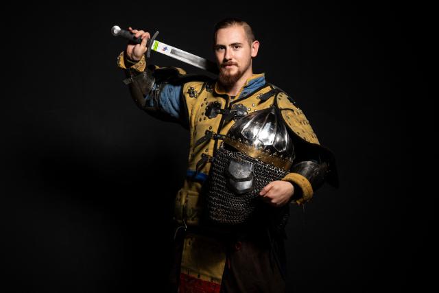 A competitor poses in his combat gear as part of the Knights of the Cage, a gala of the medieval armored combat or buhurt, in Onet-le-Chateau, southwestern France, on June 20, 2026. Fighters in armor with shields and swords, or axes, have taken part in about twenty fights in an MMA cage in Aveyron. It was overwhelmingly men who fought in individual "behourd profight" clashes, presented as the modern version of "what was the equivalent of MMA of the Middle Ages" by the town hall of Onet-le-Chateau. French, Polish, and British fighters participated in this event at the Salle d'Armes Ecole Ancienne (SAEA), a club specializing in buhurt.
"The word 'buhurt' comes from Old French; it was a recreational activity for men in the Middle Ages... It's the intersection of history and combat sports," explains Clement Carsac, president of SAEA Aveyron. 
Before the fights, participants must be weighed because, as in boxing, there are weight categories in buhurt profight. They then put on their armor and helmets, which can weigh up to six kilos. The outfit is rather expensive: "A complete set costs between 3,000 and 4,000 euros," according to Clement Carsac. (Photo by Valentine CHAPUIS / AFP)