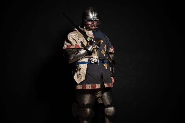 A competitor poses in his combat gear as part of the Knights of the Cage, a gala of the medieval armored combat or buhurt, in Onet-le-Chateau, southwestern France, on June 20, 2026. Fighters in armor with shields and swords, or axes, have taken part in about twenty fights in an MMA cage in Aveyron. It was overwhelmingly men who fought in individual "behourd profight" clashes, presented as the modern version of "what was the equivalent of MMA of the Middle Ages" by the town hall of Onet-le-Chateau. French, Polish, and British fighters participated in this event at the Salle d'Armes Ecole Ancienne (SAEA), a club specializing in buhurt.
"The word 'buhurt' comes from Old French; it was a recreational activity for men in the Middle Ages... It's the intersection of history and combat sports," explains Clement Carsac, president of SAEA Aveyron. 
Before the fights, participants must be weighed because, as in boxing, there are weight categories in buhurt profight. They then put on their armor and helmets, which can weigh up to six kilos. The outfit is rather expensive: "A complete set costs between 3,000 and 4,000 euros," according to Clement Carsac. (Photo by Valentine CHAPUIS / AFP)
