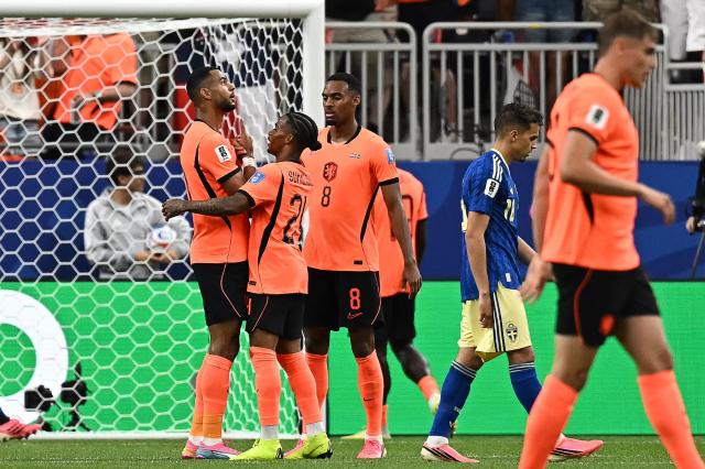 Netherlands' forward #11 Cody Gakpo (L) celebrates with teammates after scoring his team's fourth goal during the 2026 World Cup Group F football match between the Netherlands and Sweden at the Houston Stadium in Houston on June 20, 2026.  (Photo by Paul ELLIS / AFP)