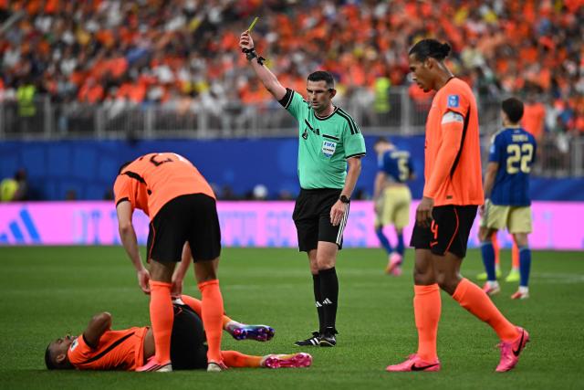 English referee Michael Oliver (C) shows a yellow card   during the 2026 World Cup Group F football match between the Netherlands and Sweden at the Houston Stadium in Houston on June 20, 2026.  (Photo by Paul ELLIS / AFP)
