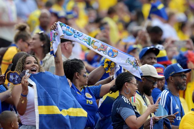 Curacao fans cheer for their team ahead of the 2026 World Cup Group E football match between Ecuador and Curacao at the Kansas City Stadium in Kansas City on June 20, 2026.  (Photo by JUAN MABROMATA / AFP)