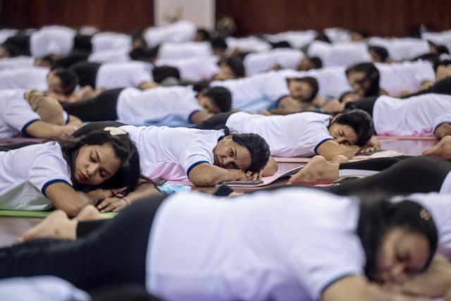 People take part in a yoga session to celebrate International Yoga Day at the Thuwanna Indoor Stadium in Yangon on June 21, 2026. (Photo by Sai Aung MAIN / AFP)