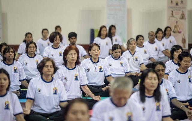 People take part in a yoga session to celebrate International Yoga Day at the Thuwanna Indoor Stadium in Yangon on June 21, 2026. (Photo by Sai Aung MAIN / AFP)