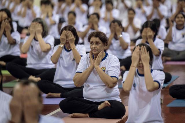 People take part in a yoga session to celebrate International Yoga Day at the Thuwanna Indoor Stadium in Yangon on June 21, 2026. (Photo by Sai Aung MAIN / AFP)