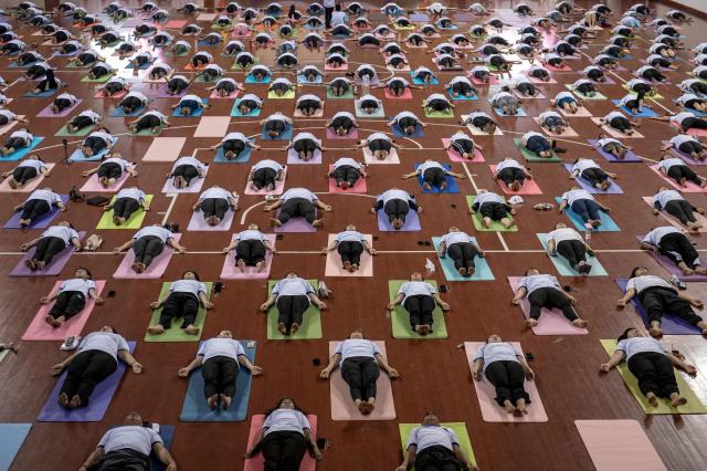 People take part in a yoga session to celebrate International Yoga Day at the Thuwanna Indoor Stadium in Yangon on June 21, 2026. (Photo by Sai Aung MAIN / AFP)