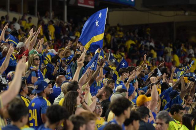 Curacao's fans celebrate at the end of the 2026 World Cup Group E football match between Ecuador and Curacao at the Kansas City Stadium in Kansas City on June 20, 2026.  (Photo by JUAN MABROMATA / AFP)