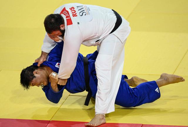 Kim Min-jong of South Korea (blue) and Inal Tasoev of Russia compete in men’s +100kg semifinal at the Judo Ulaanbaatar Grand Slam in Ulaanbaatar on June 21, 2026. (Photo by ADEK BERRY / AFP)