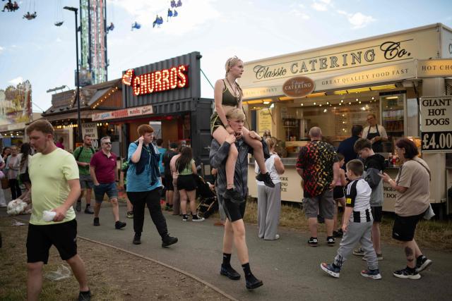 Members of the public attend The Hoppings fun fair, believed to be one of the largest travelling funfairs in Europe, in Newcastle upon Tyne, north east England on June 20, 2026. The fun fair, which originally began as a Temperance Fair in 1882, comprises of over 400 attractions set up on the city's Town Moor. The fair runs until June 28, 2026 and is expected to attract around 500,000 people. (Photo by Oli SCARFF / AFP)