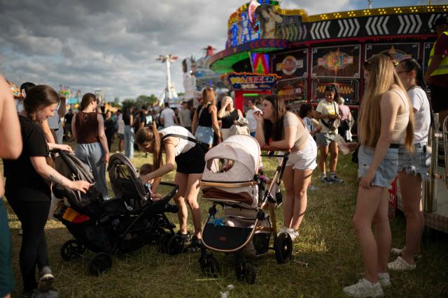 Members of the public attend The Hoppings fun fair, believed to be one of the largest travelling funfairs in Europe, in Newcastle upon Tyne, north east England on June 20, 2026. The fun fair, which originally began as a Temperance Fair in 1882, comprises of over 400 attractions set up on the city's Town Moor. The fair runs until June 28, 2026 and is expected to attract around 500,000 people. (Photo by Oli SCARFF / AFP)