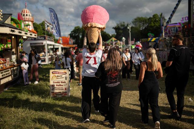 Members of the public attend The Hoppings fun fair, believed to be one of the largest travelling funfairs in Europe, in Newcastle upon Tyne, north east England on June 20, 2026. The fun fair, which originally began as a Temperance Fair in 1882, comprises of over 400 attractions set up on the city's Town Moor. The fair runs until June 28, 2026 and is expected to attract around 500,000 people. (Photo by Oli SCARFF / AFP)