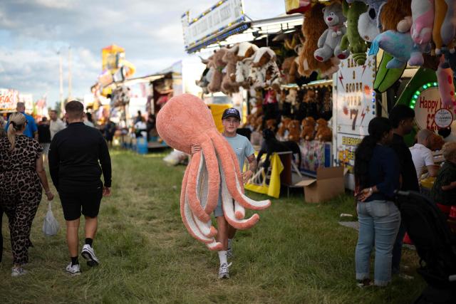 Members of the public attend The Hoppings fun fair, believed to be one of the largest travelling funfairs in Europe, in Newcastle upon Tyne, north east England on June 20, 2026. The fun fair, which originally began as a Temperance Fair in 1882, comprises of over 400 attractions set up on the city's Town Moor. The fair runs until June 28, 2026 and is expected to attract around 500,000 people. (Photo by Oli SCARFF / AFP)